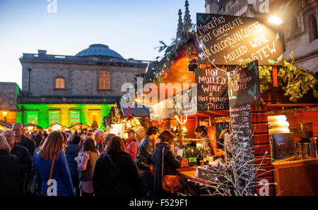 Christmas Market Bath with Roman Baths and Bath Abbey in background people at mulled wine stall Bath Somerset England UK Stock Photo