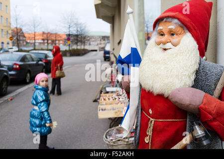 Little girl looking at Santa Claus figure at a souvenirs shop in Töölö district, Helsinki, Finland Stock Photo