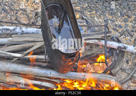 Cooking soup from a pike at the stake. The fire, pots and accessories. Stock Photo
