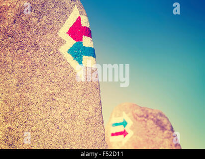 Vintage toned trail signs painted on rock, choice or dilemma concept. Stock Photo