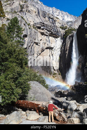 Visitor admires Lower Yosemite Fall in Yosemite National Park Stock Photo
