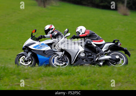 Motorcycles BMW K 1300 S HP and Honda VFR 1200 F DCT, year of construction in 2012, driving, country road, panning in front of meadow, Stock Photo