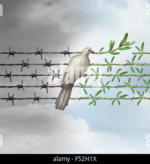 Hope concept as a dove perched on barbed wire transforming into an olive branch as a symbol for good will towards man and a respect for humanity and the globe as a new year or holiday greeting with a wish and dream of a safer world. Stock Photo