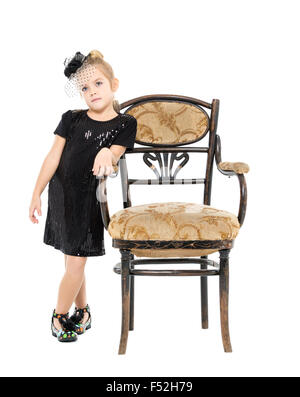 Little Girl Standing near Antique Chair, on white background Stock Photo