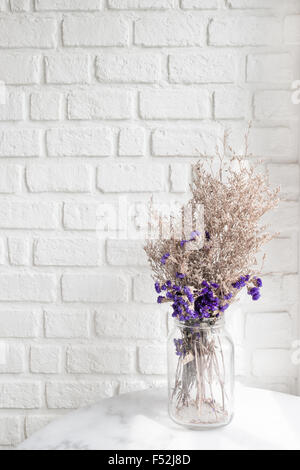 Composition of dried flowers on white wall brick in background Stock Photo