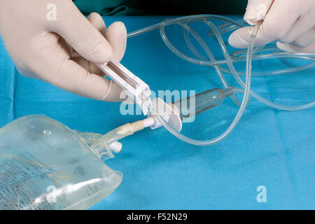 Nurse adjust IV drip rate with saline solution. Stock Photo