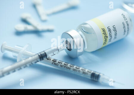 Insulin syringe draws insulin from regular insulin vial with lancets. Stock Photo