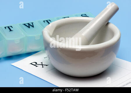 Mortar and pestle with prescription and daily pill dispenser. Stock Photo