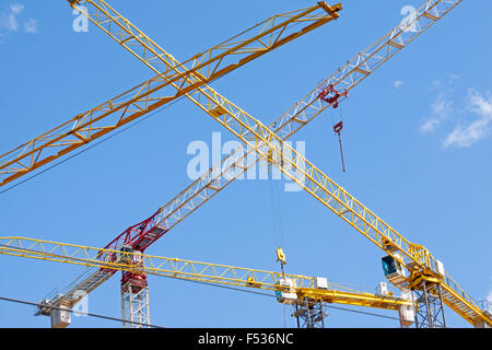 Industrial construction cranes over clear blue sky Stock Photo