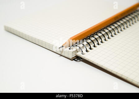 Opened notebook with a blank sheet and pencil on over white Stock Photo