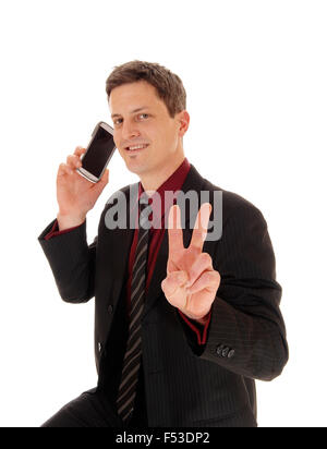 A closeup shoot of a man his cell phone on his ear and sign victory with two fingers, isolated for white background. Stock Photo