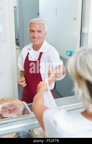 Butcher serving customer meat counter of grocery store Stock Photo - Alamy