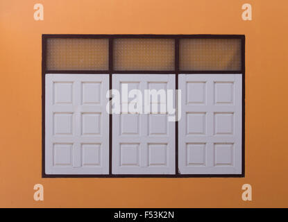 white wooden window with orange wall background Stock Photo