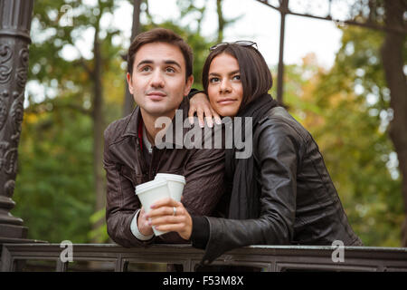 Portrait of a beautiful young couple standing with coffee outdoors Stock Photo