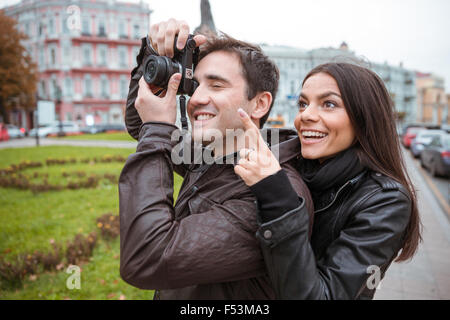 Portrait of a happy young couple traveling and making photo on camera in old european city Stock Photo