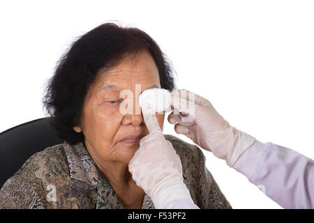doctor bandaging patient's eye on white background Stock Photo
