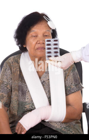 pills with senior woman injured on white background Stock Photo