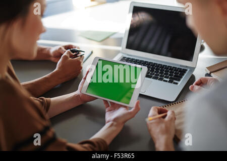 Colleagues using digital tablet to solve work issues Stock Photo