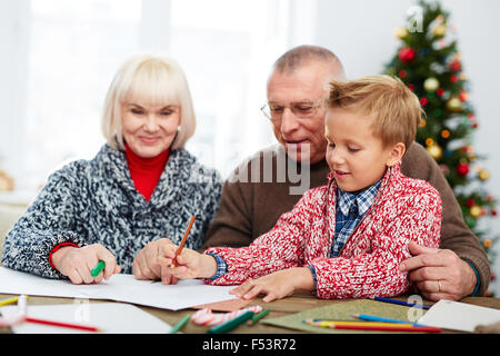 Boy writing a letter to Santa with his grandparents Stock Photo