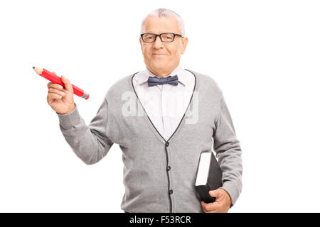 Mature school teacher holding a big red pencil in one hand and a book in the other isolated on white background Stock Photo