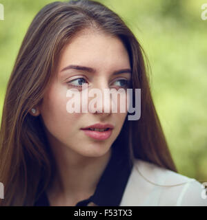 Young caucasian student girl with long dark hair at the outdoor park. Stock Photo
