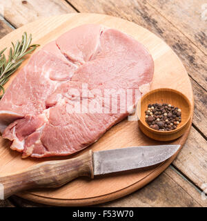 Chunk of meat with knife and pepper on wood background. Beefsteak menu and recipe background Stock Photo