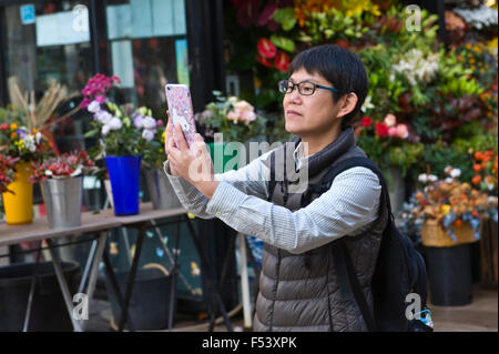 Tourist using smartphone to take photograph on La Rambla in Barcelona Catalonia Spain ES Stock Photo