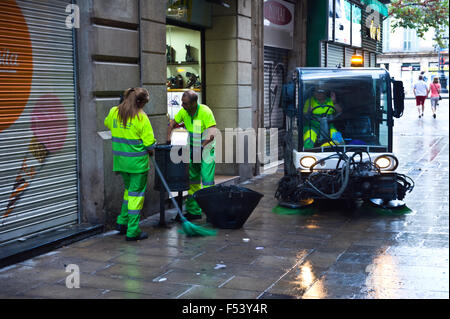 Street cleaners emptying litter bin & sweeping street in Barcelona Catalonia Spain ES Stock Photo