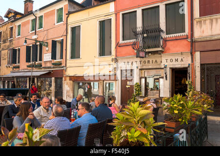 Customers dining in the square outside Trattoria Toma, San Toma, Venice, Italy Stock Photo