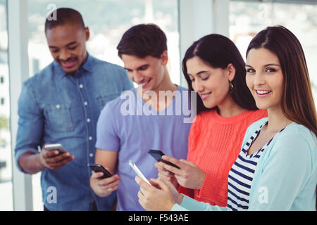 Young creative team looking at phones Stock Photo - Alamy