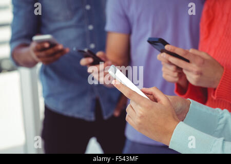 Young creative team looking at phones Stock Photo - Alamy