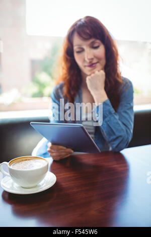 Mature student using tablet in cafe