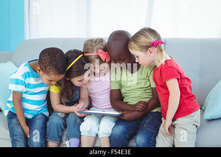 Happy kids using technology while sitting Stock Photo