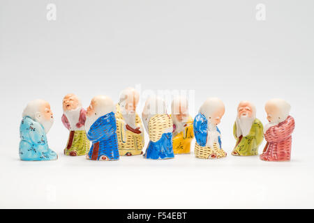 Scene with nine ancient  porcelain figurines of the Chinese sages on white background Stock Photo