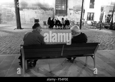 Old elderly men and women sitting outside at night at Ubeda in Andalusia Spain Stock Photo