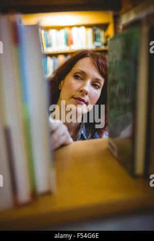 Mature student picking out book in library Stock Photo