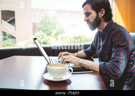 Hipster student using laptop in canteen Stock Photo