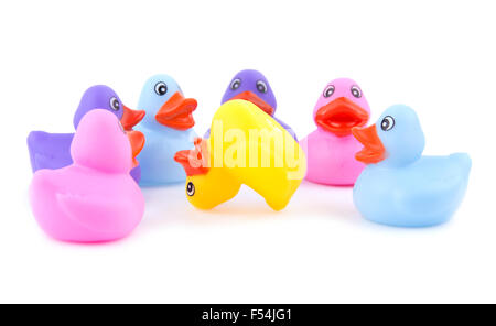 Colorful rubber ducks around an upside down duck, on white - concept of bullying Stock Photo