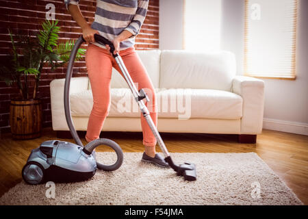 Woman hoovering the rug Stock Photo