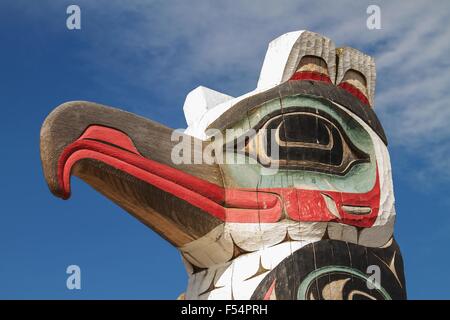 Detail of totem pole in Alaska. Horizontal photo with blue sky in the background. Stock Photo