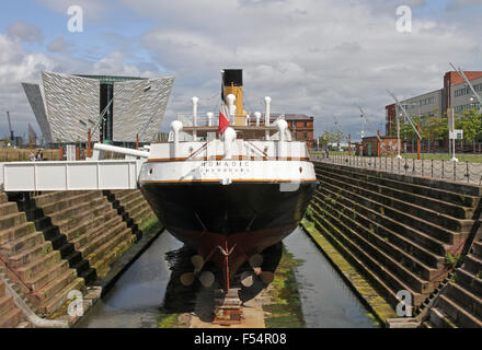 The SS Nomadic in Hamilton Dock, Belfast with The Titanic Visitors' Centre in the background. Stock Photo