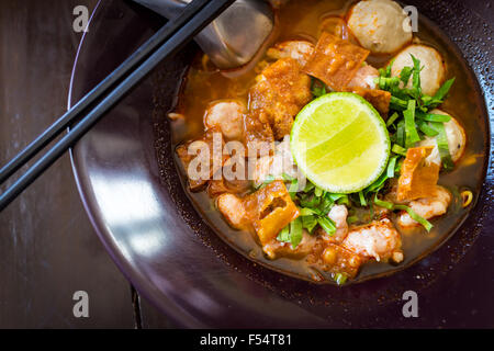 Thai Noodles spicy tom yum soup with pork and lemon on topping street food in thailand Stock Photo
