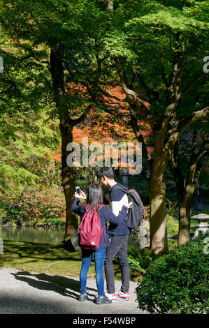 Two young Asian students taking a selfie, Nitobe Memorial Garden, University of British Columbia, Vancouver, Canada Stock Photo