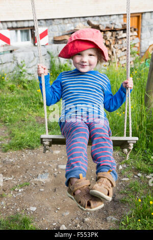 Portrait of cute boy swinging at park Stock Photo