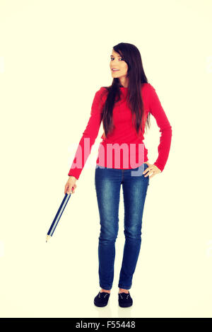 Beautiful woman pointing down with a big pencil. Stock Photo