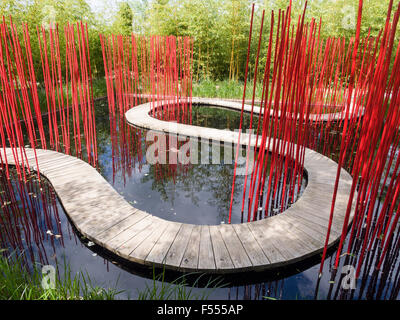 Carré et Rond by Yu Kongjian. A curving boardwalk through a black pond with bright red poles to guide your way through the curve Stock Photo