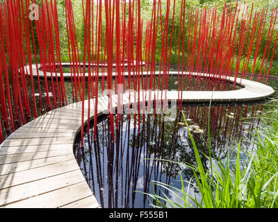 Carré et Rond by Yu Kongjian. A curving boardwalk through a black pond with bright red poles to guide your way through the curve Stock Photo