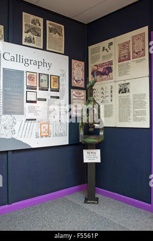 Keswick Pencil Museum.  Old Fly Press exhibited alongside a wall display on Calligraphy. Keswick, Cumbria, England UK Stock Photo