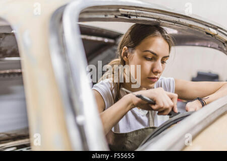 Female mechanic repairing car at garage Stock Photo