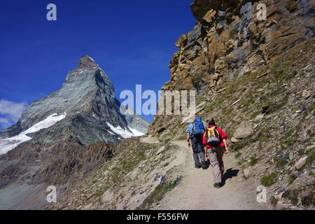 Hikers on trail to the Hörnli hut at abse of Matterhorn, Zermatt, Swiss alps, Valais, Wallis, Switzerland Stock Photo